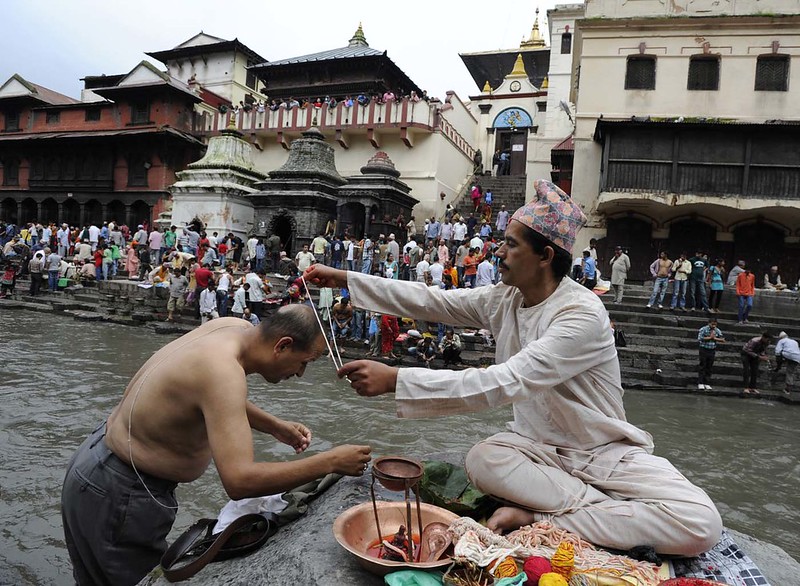 On the occasion of the Janai Purnima Festival, a Nepalese Hindu devotee is presented with a Janai (sacred thread) by a Hindu Brahmin